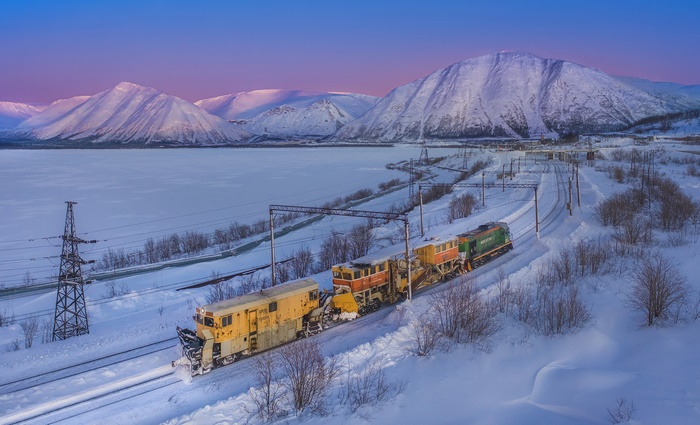 Train in a snowy mountain landscape at dusk