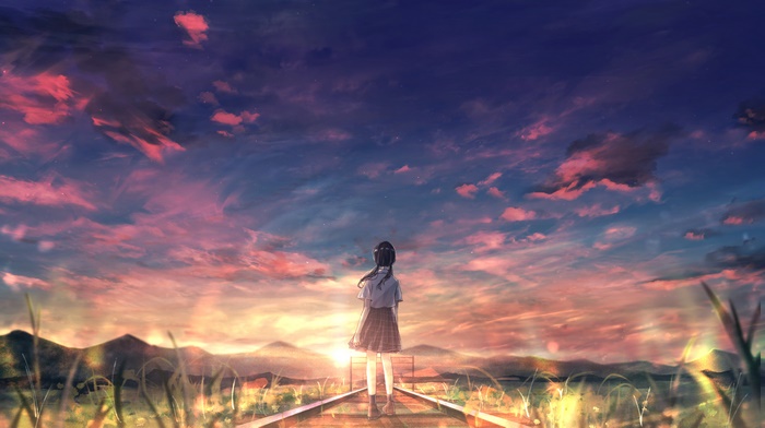 Girl watching sunset on train tracks