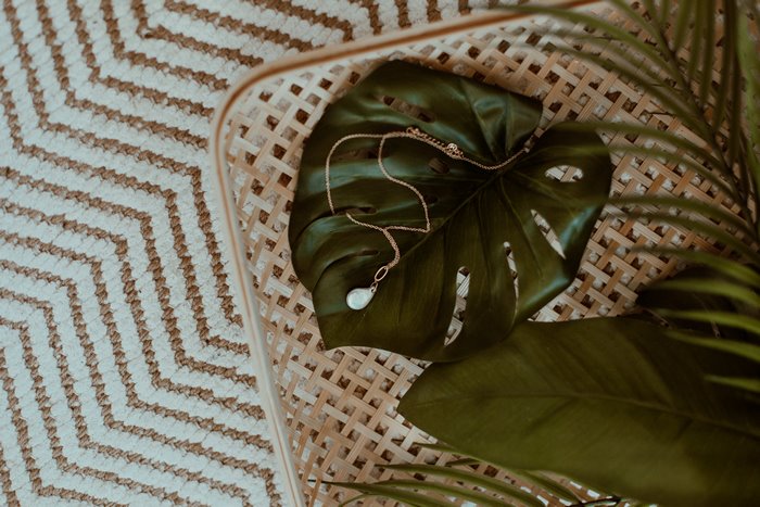 Necklace on a Monstera leaf on a woven surface