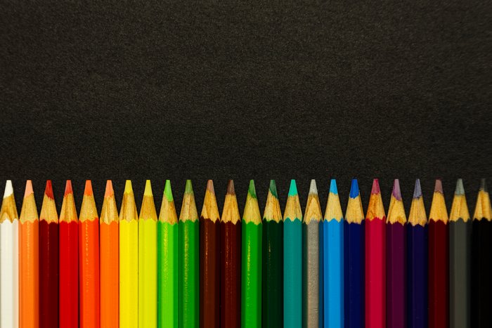 Colored Pencils Lined Up on a Black Surface