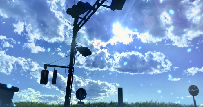 Traffic light against a cloudy sky with sun