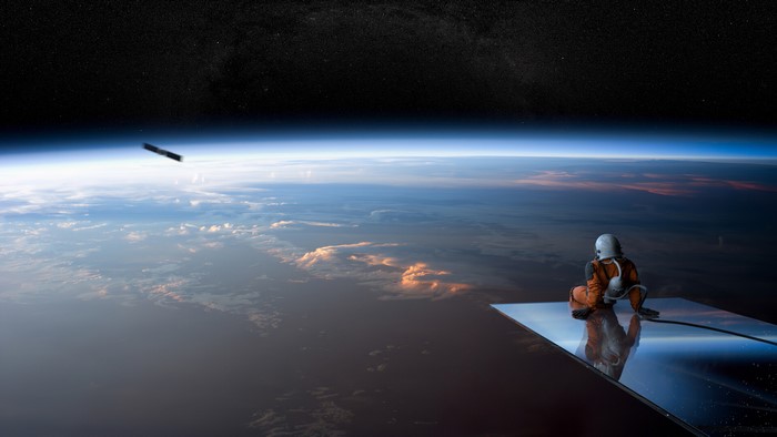 Astronaut sitting on a reflective surface in space
