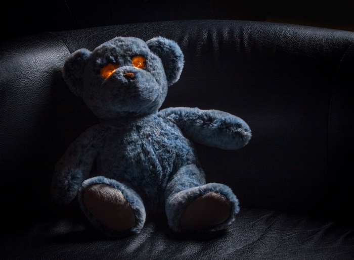 Blue teddy bear with glowing orange eyes