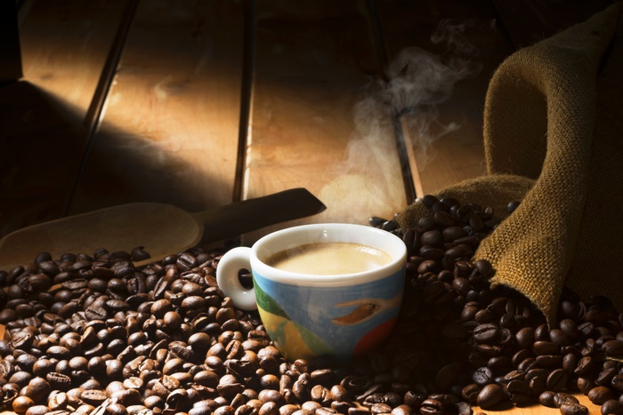 Coffee cup with steam and coffee beans