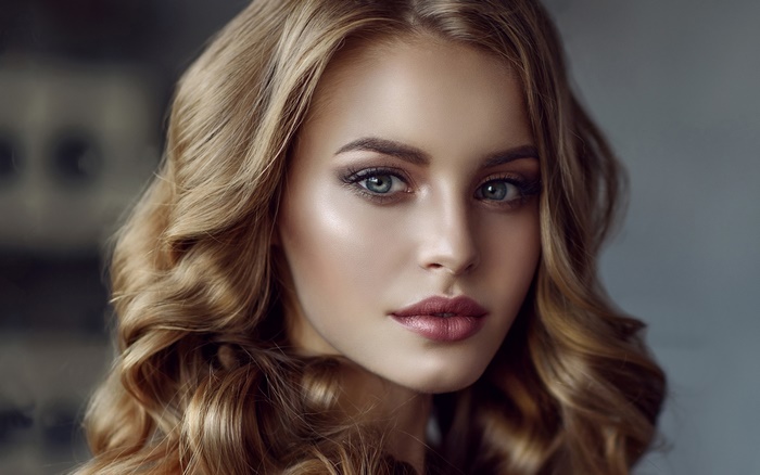 Woman with blonde wavy hair and blue eyes