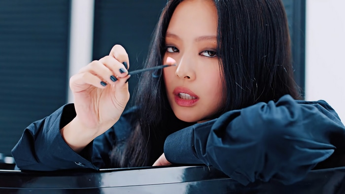 Jennie from BLACKPINK holding a lit match