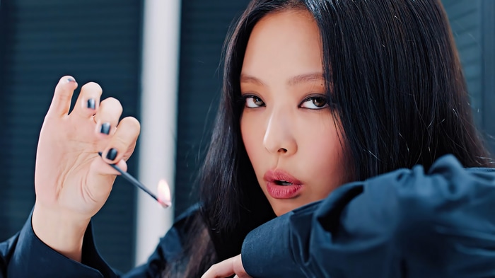 Jennie from BLACKPINK holding a lit match