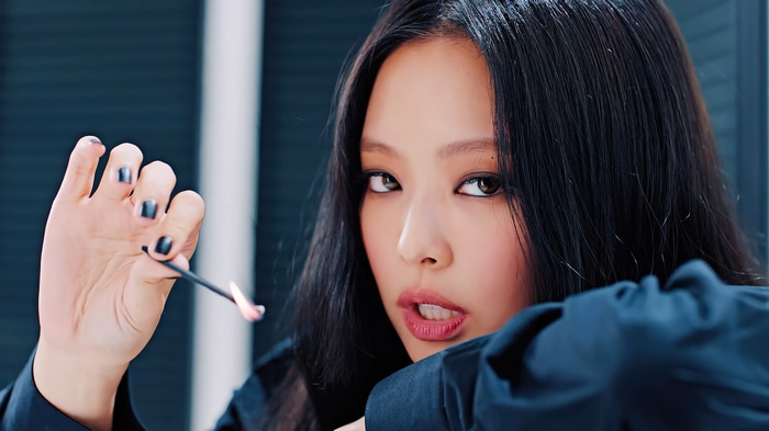 Jennie from BLACKPINK holding a burning match