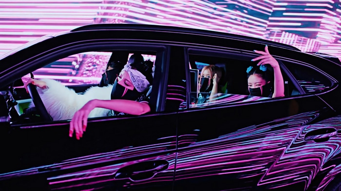 BLACKPINK members in a car with neon lights