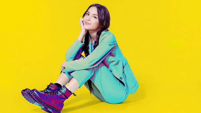 Olivia Rodrigo in a teal suit and iridescent boots