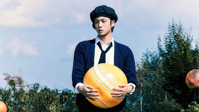 Jin from BTS holding a striped ball