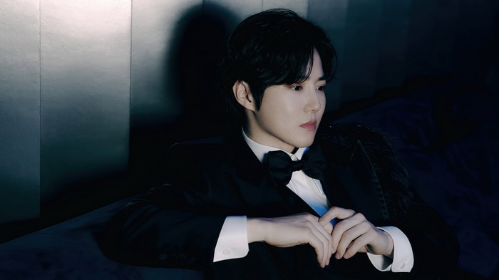 Suho in a black tuxedo with a bow tie