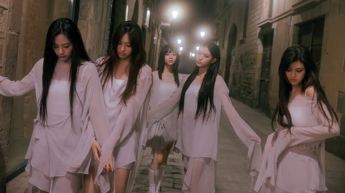 NewJeans members in white dresses on a street