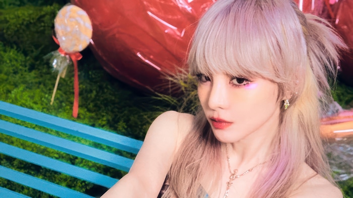 Sandara Park in a whimsical setting with a lollipop