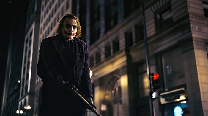 Joker with a shotgun in a city at night