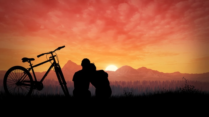 Couple and bicycle silhouette at sunset 4K