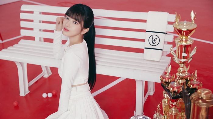 Yujin from IVE in a white outfit with trophies