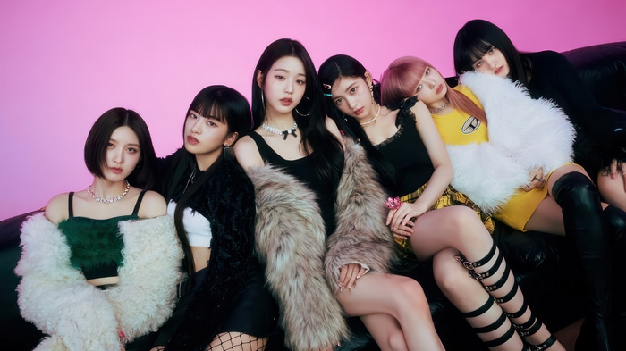 IVE members posing on a black couch