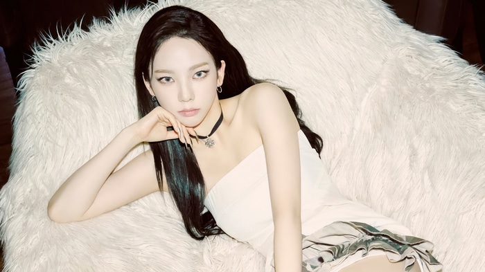 Karina from Aespa posing on a fluffy white couch
