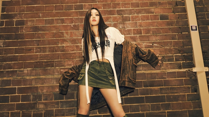 Aespa Giselle in a brown jacket and green skirt