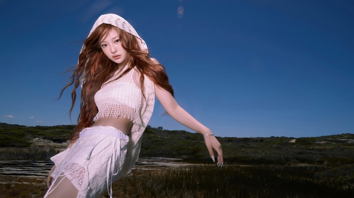 Ningning from Aespa in a white outfit under a blue sky