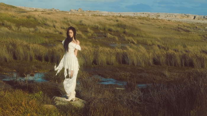 Aespa Giselle in a white dress in a marsh