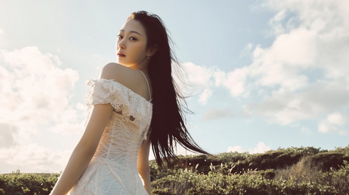 Aespa Giselle in a white dress under the sky