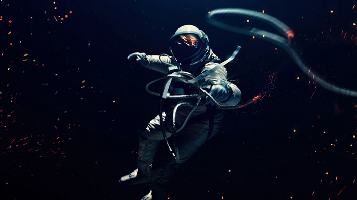 Astronaut floating in space with debris