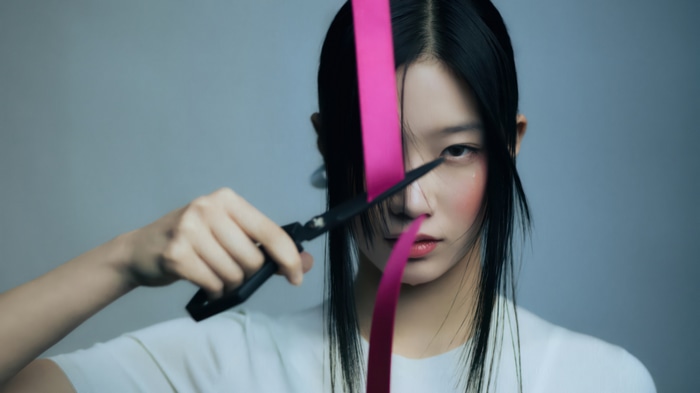 Kazuha of LE SSERAFIM cuts pink ribbon with scissors