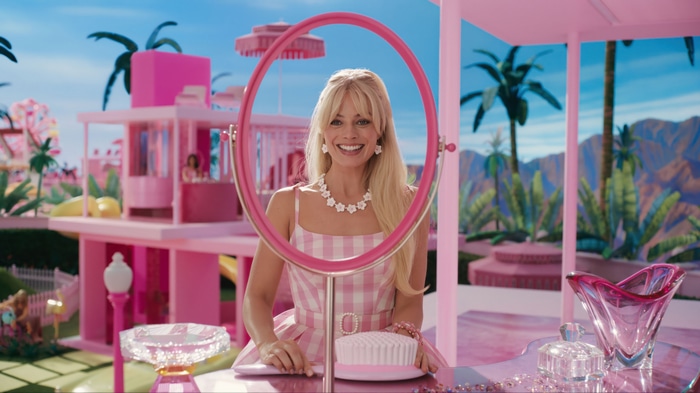 Margot Robbie as Barbie in a pink checkered dress