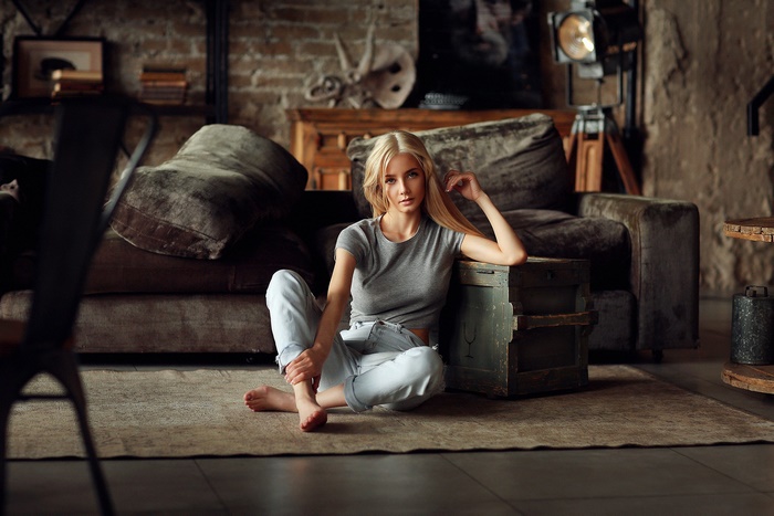 Blonde Woman Sitting by Sofa