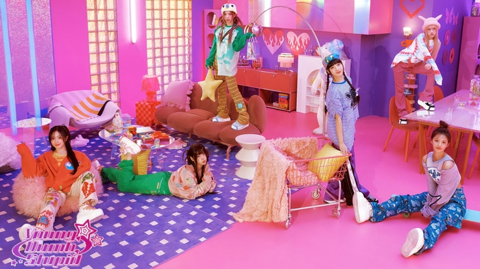 NMIXX members in a colorful, playful room