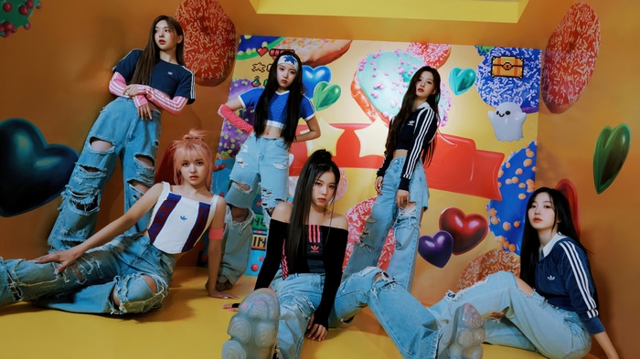 NMIXX members in a colorful, donut-themed room