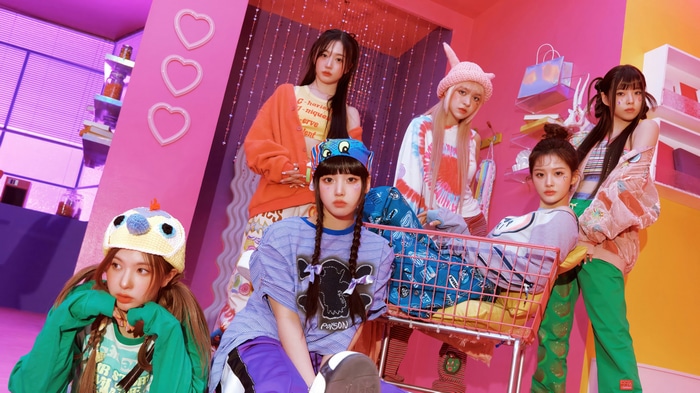 NMIXX members posing in a colorful room