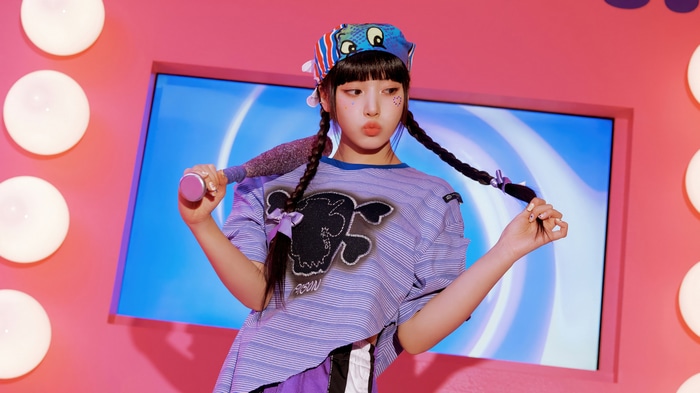 NMIXX Jiwoo in a purple striped shirt and bandana