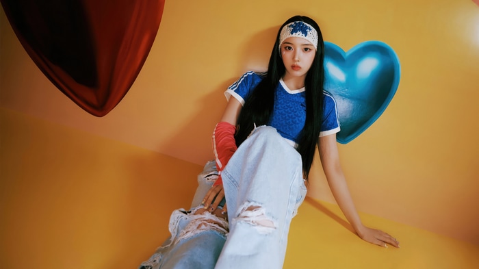 NMIXX Jiwoo in a blue top and ripped jeans