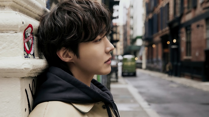 J-Hope of BTS leaning against a pillar in an alley
