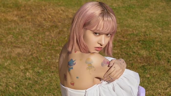 NMIXX Lily with tattoos in a field