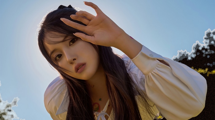 Jiwon from NMIXX posing against the sky