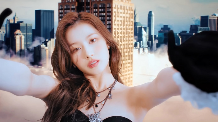 Sana from TWICE in front of a city skyline