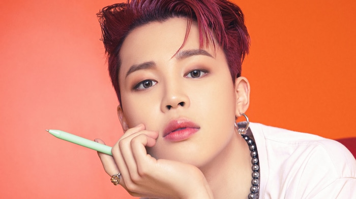 Jimin of BTS holding a pen