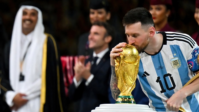 Lionel Messi kisses the FIFA World Cup trophy