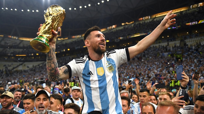 Lionel Messi holding the FIFA World Cup trophy