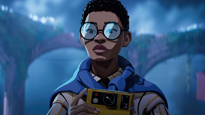 A young person with glasses holds a camera