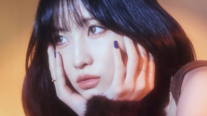 Momo from TWICE with dark hair and blue nails