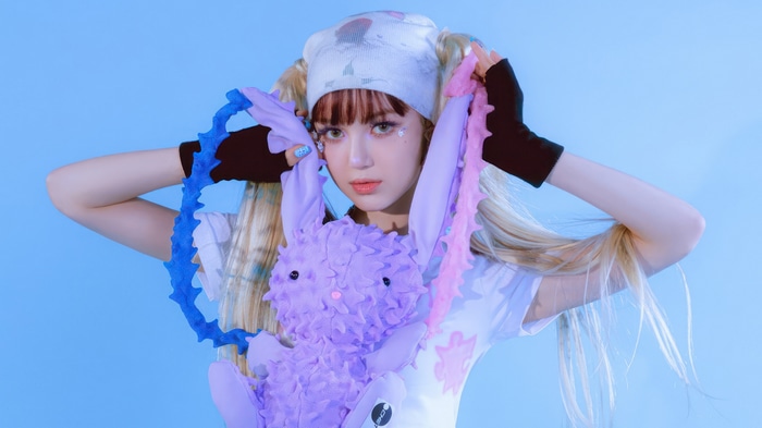 Danielle from NewJeans holding a purple bunny plush