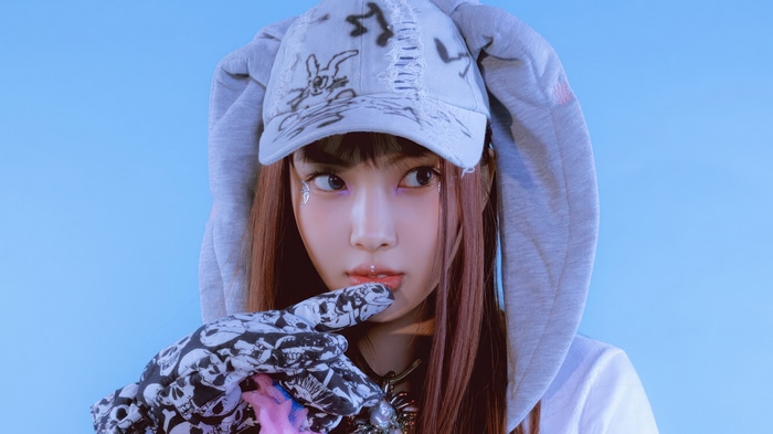 Hyein from NewJeans wearing a hoodie and cap