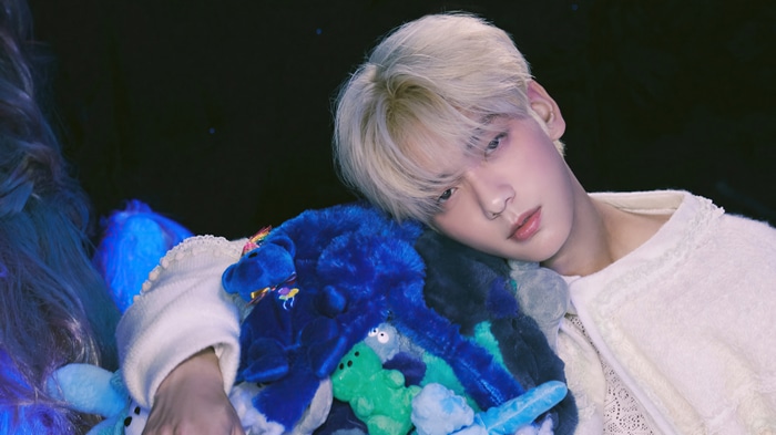 Soobin of TXT leans on stuffed toys