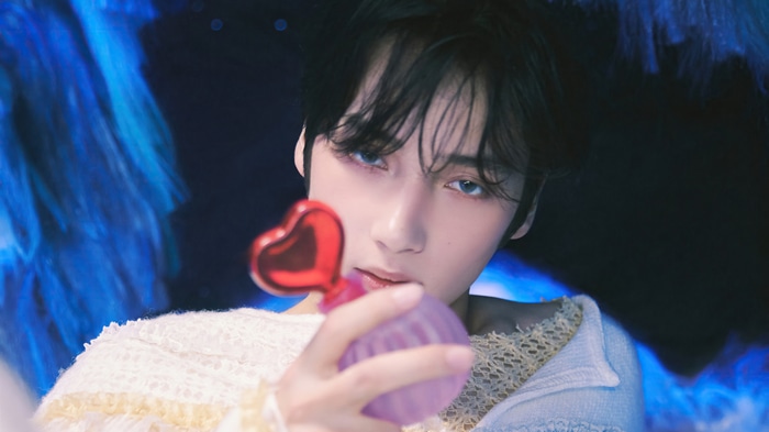 Huening Kai of TXT holds a heart-shaped perfume bottle