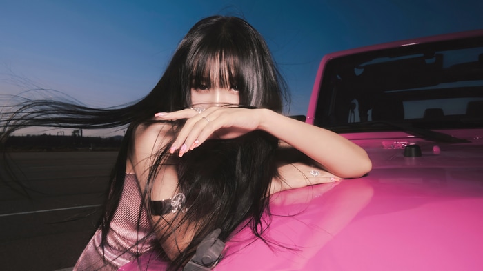 Joy from Red Velvet leans on a pink car
